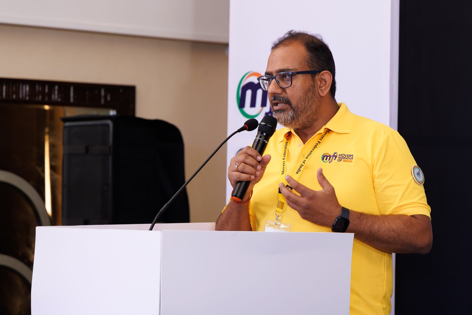 Conference speaker holding a microphone behind a lectern