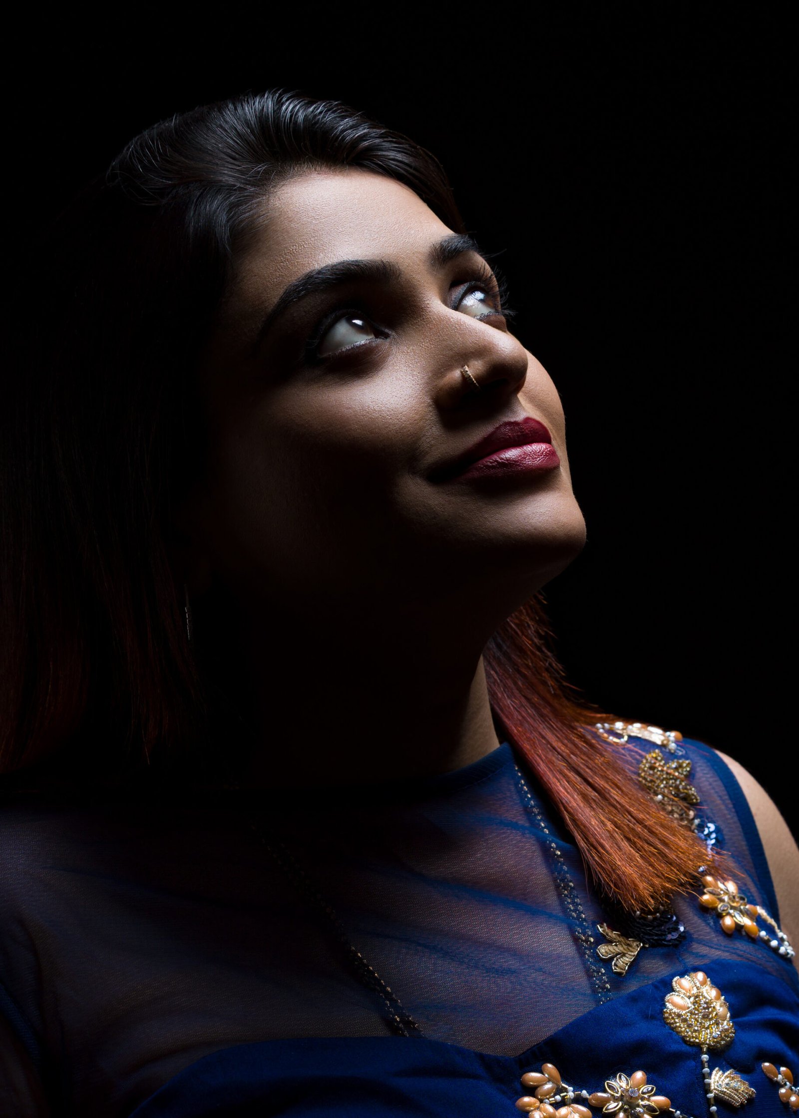 Dramatically lit portrait of a woman against a dark background