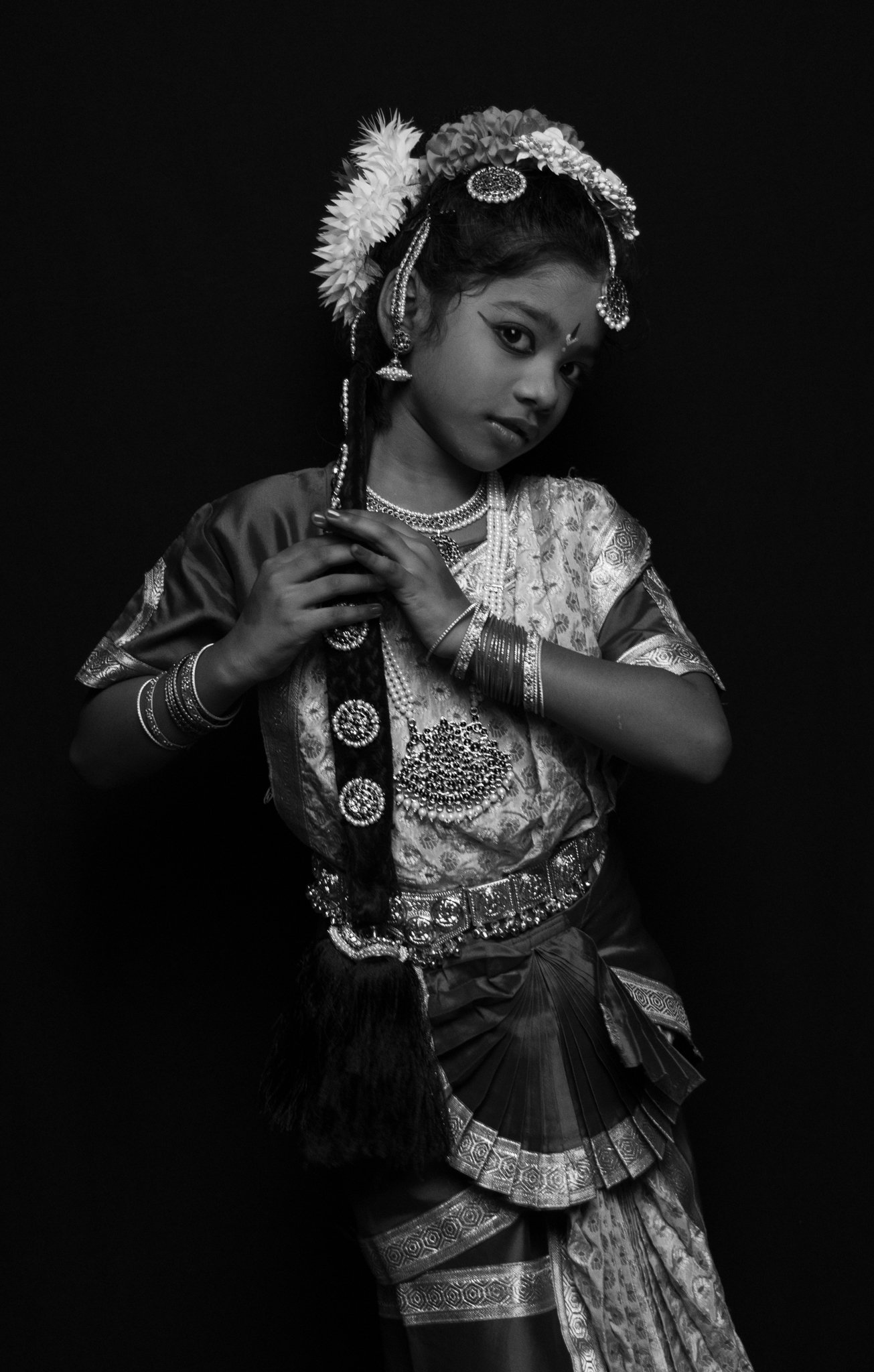 Black and white studio portrait of a child wearing a traditional dance costume