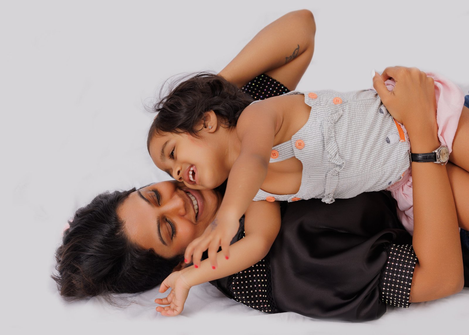 Mother and young child smiling together during a relaxed studio portrait