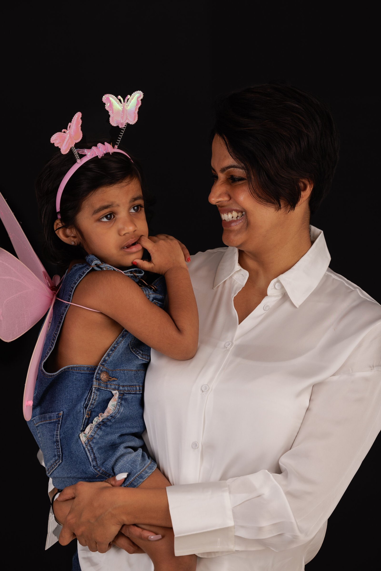 Mother holding her daughter wearing a butterfly headband