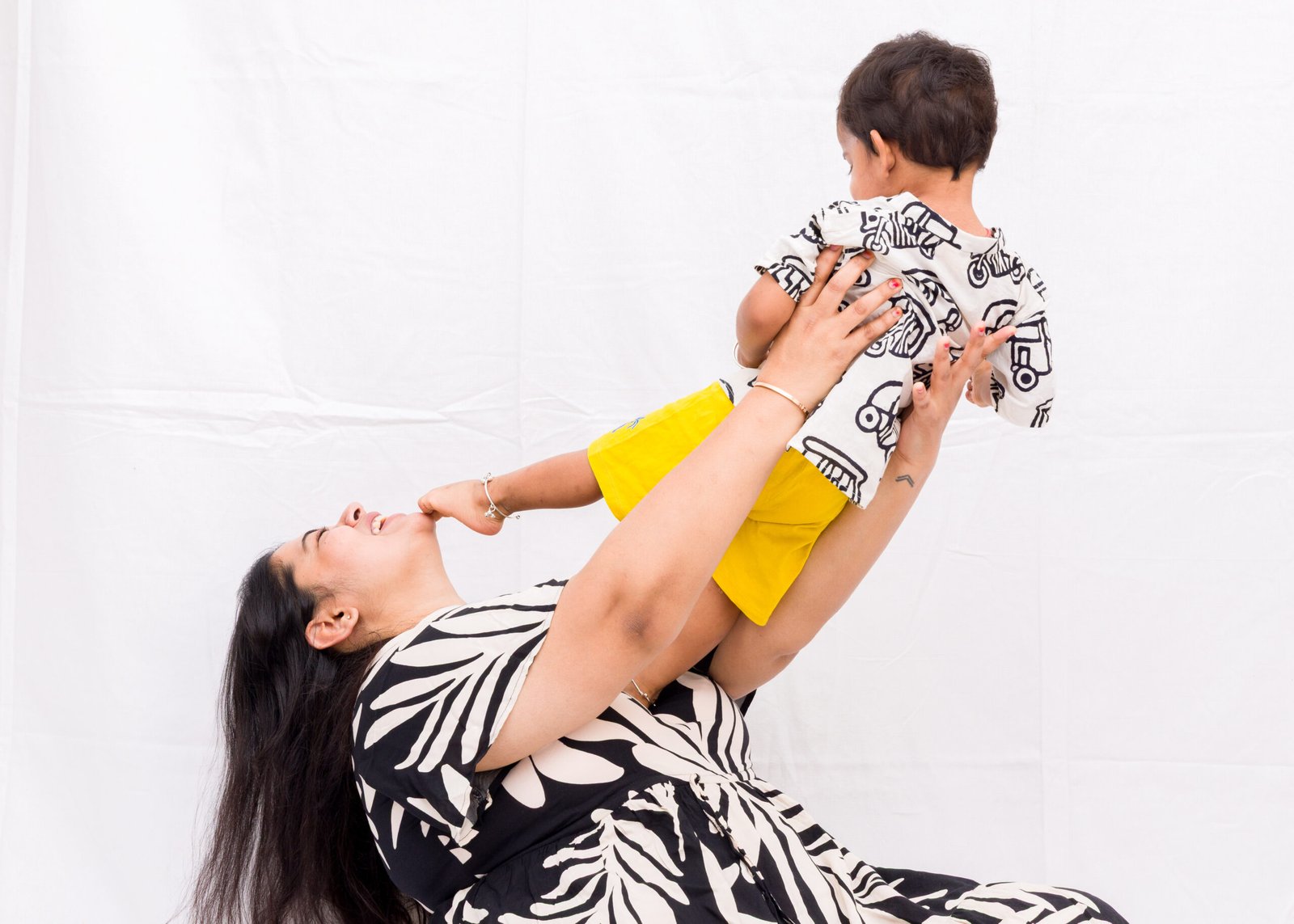Mother lifting her young child during a playful studio portrait
