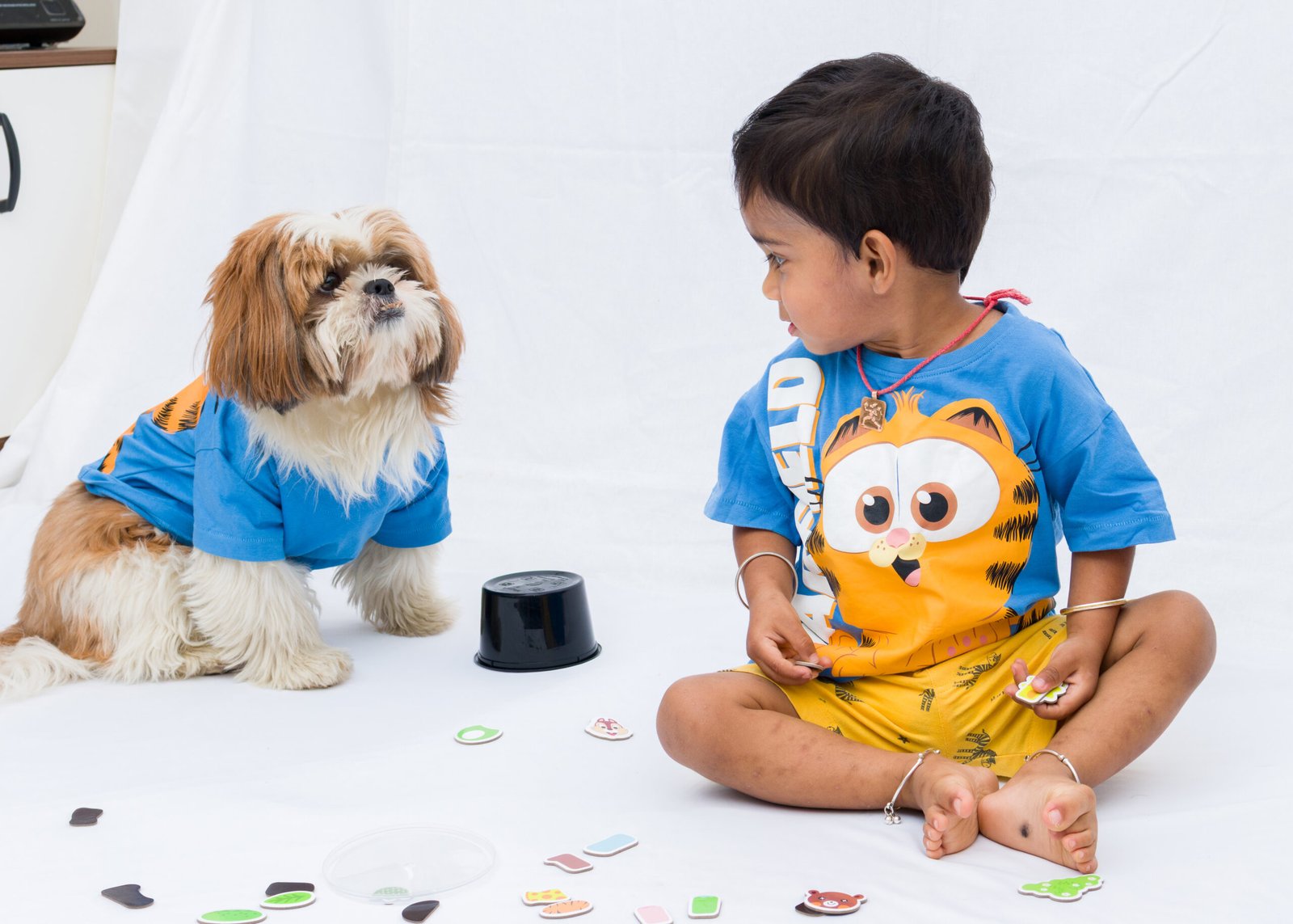 Young boy looking toward his dog during a playful studio session