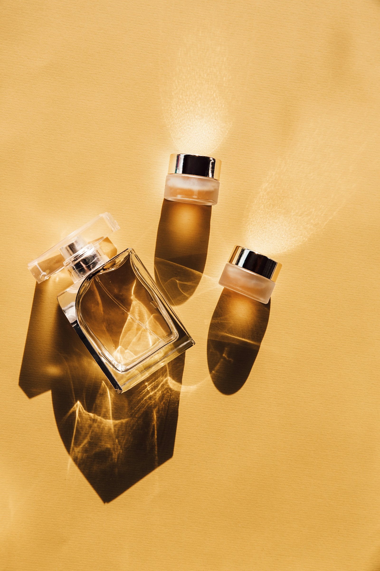 Glass skincare bottles in warm studio light