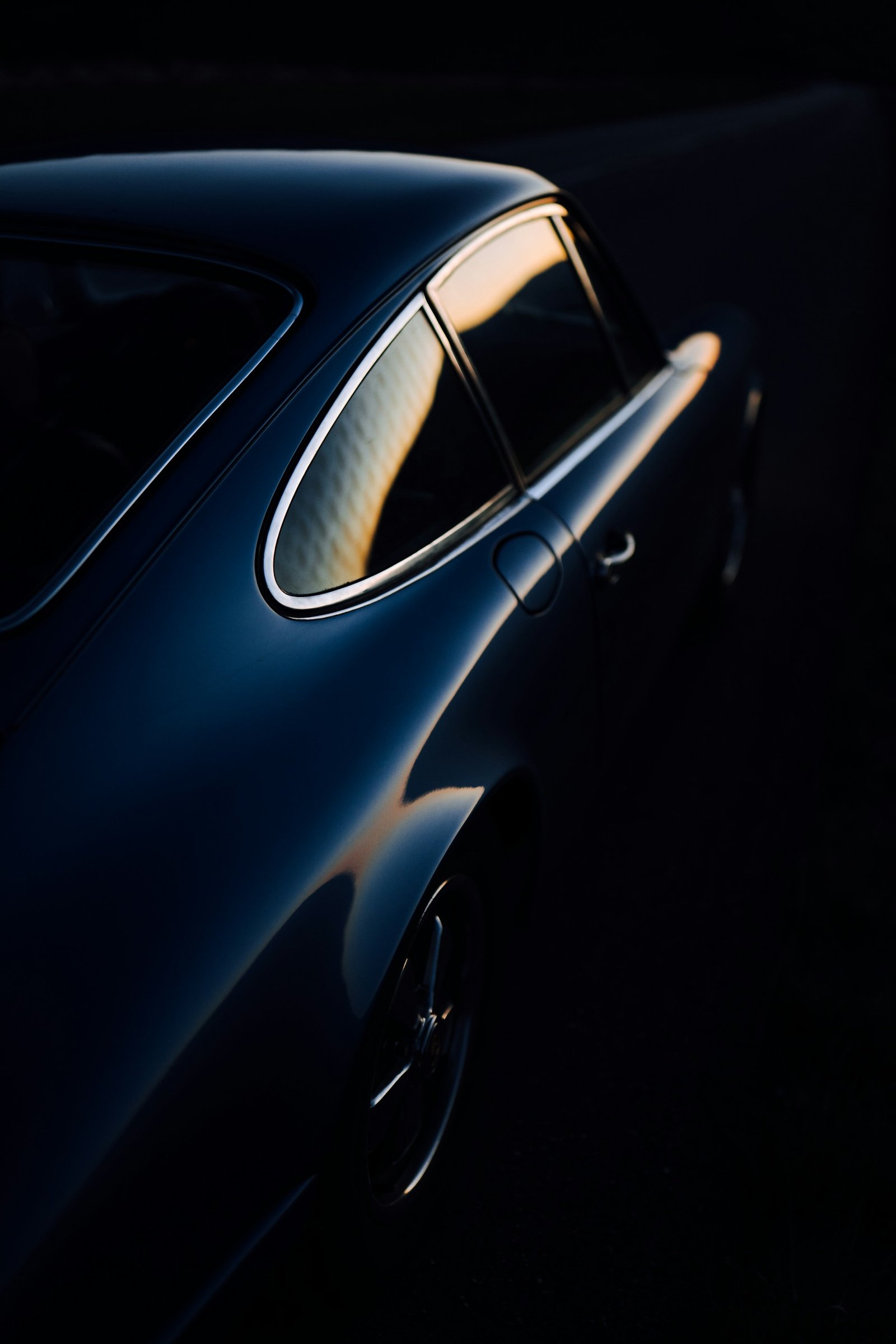 Sculpted rear quarter of a dark blue sports car