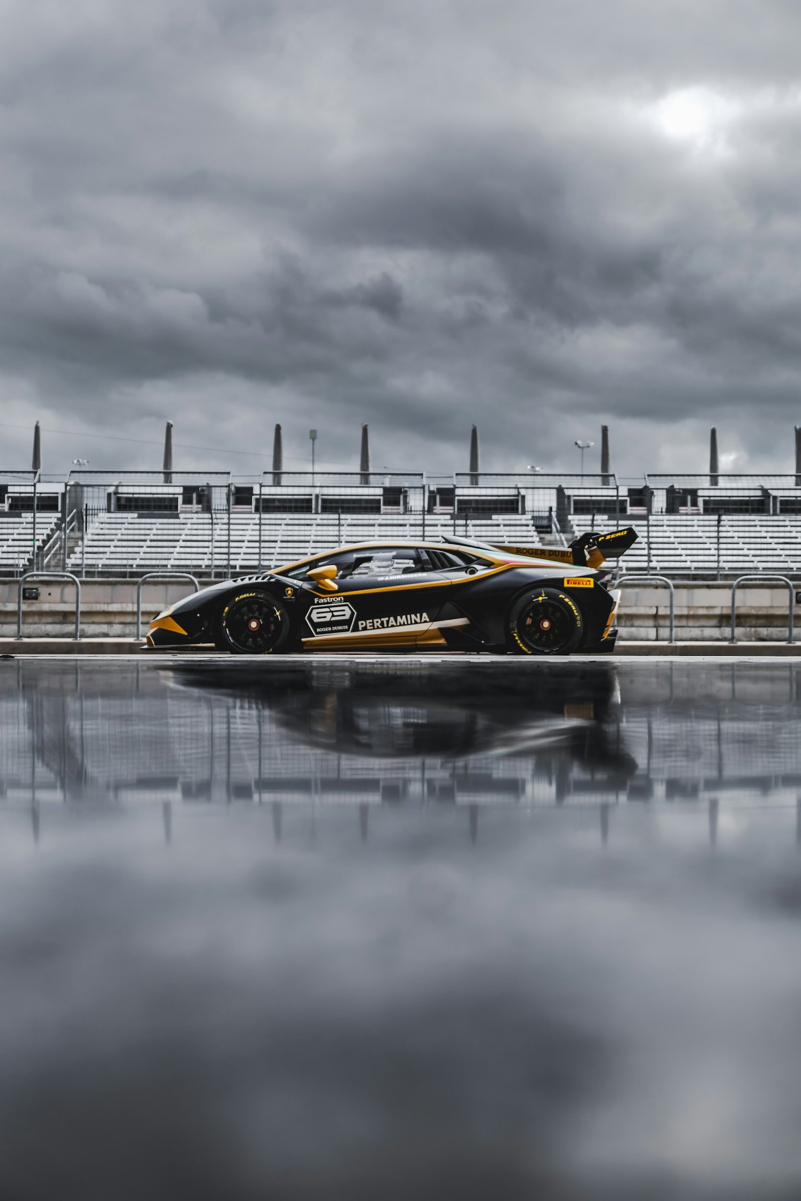 Yellow and black sports car on wet pavement