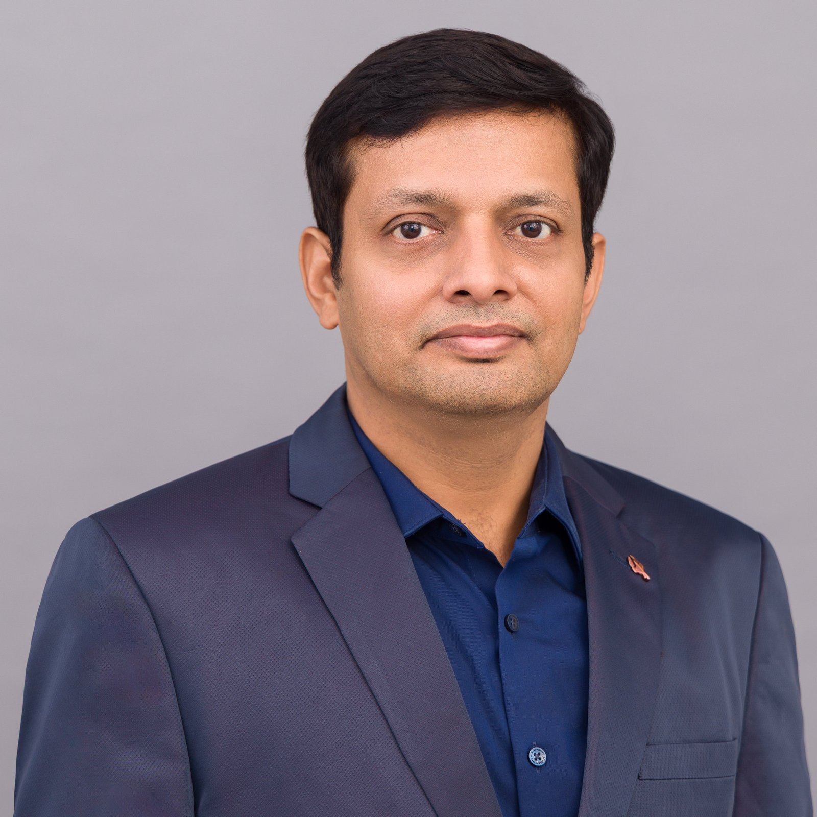Corporate headshot of a man in a navy jacket
