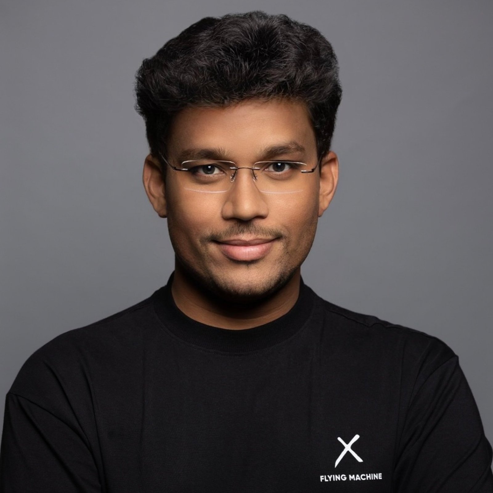 Studio headshot of a man in a black branded shirt