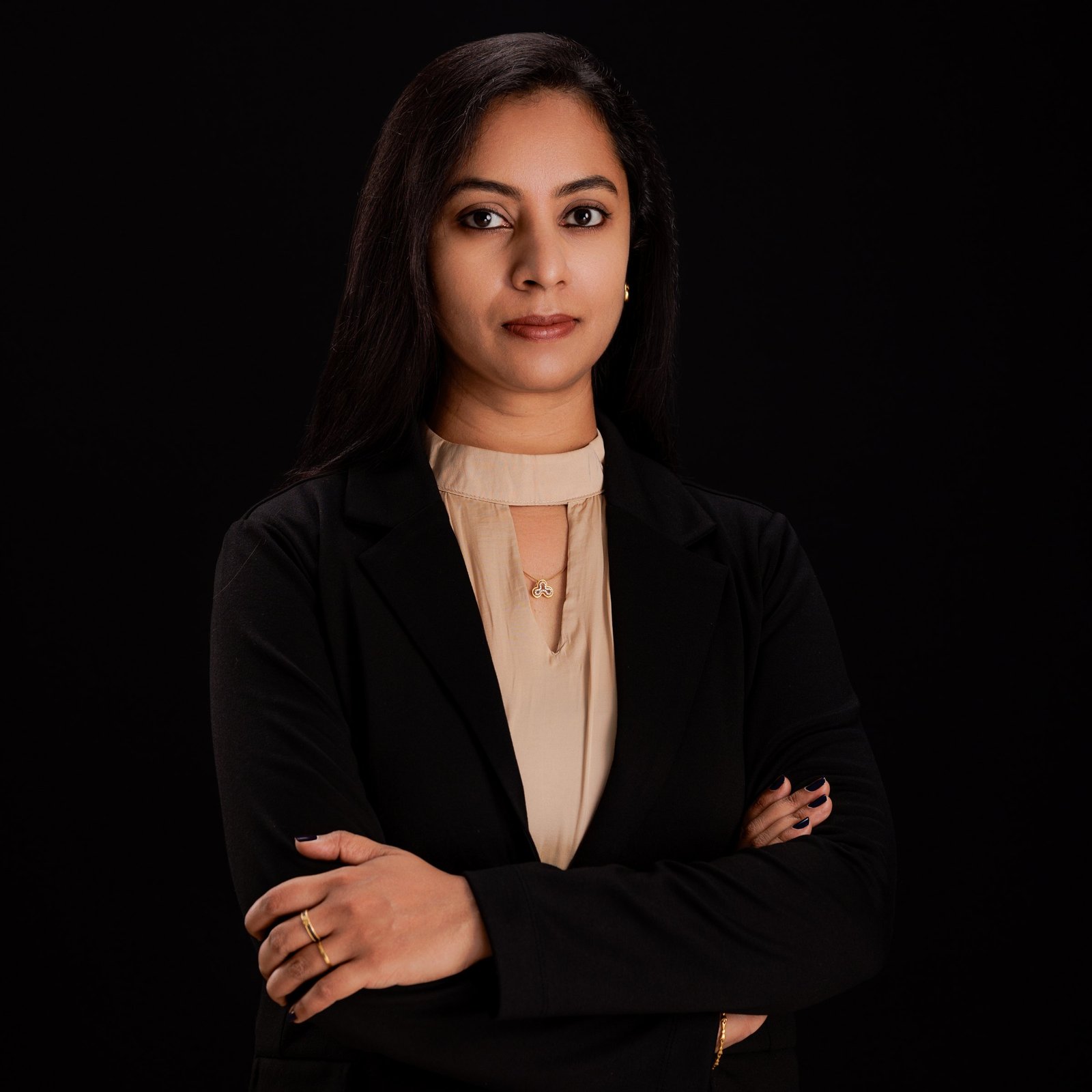 Studio portrait of a woman with folded arms in a black blazer
