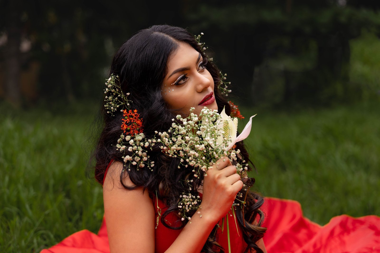 Outdoor fashion portrait in a red gown with flowers