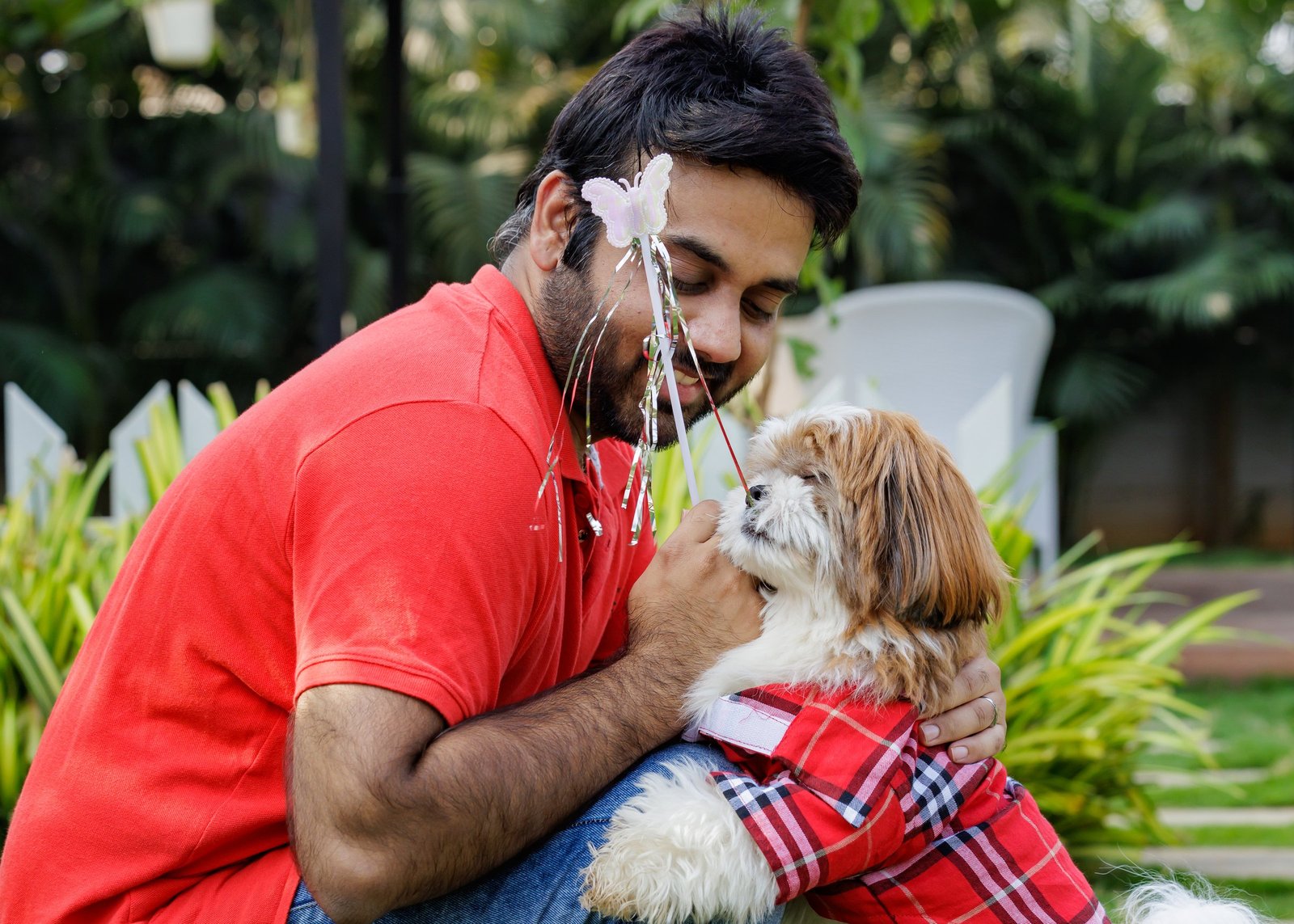 Man cuddling a small dog outdoors